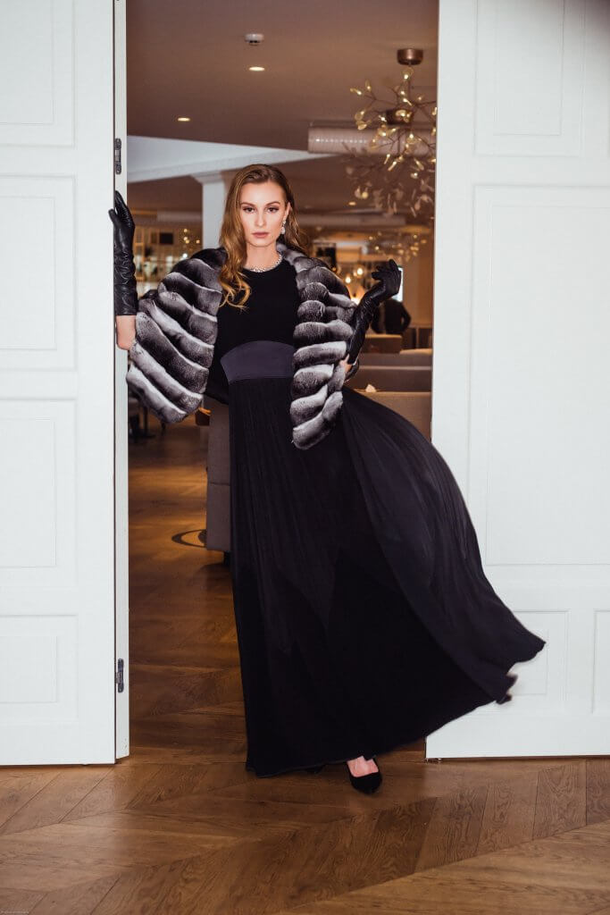 Full-length evening look with a silver and charcoal fur jacket