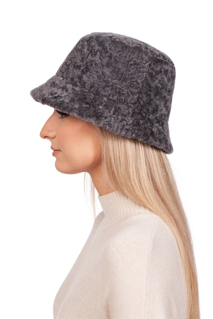 A person with long blonde hair is shown in profile view against a white background, wearing a beige sweater and the Grey Lambskin Fisherman’s Hat by FurbySD.