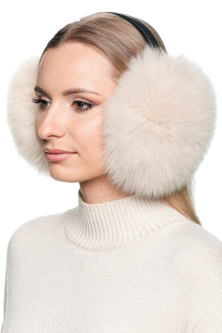 Side profile of woman wearing beige fox fur earmuffs with black leather band – handmade fluffy winter ear warmers for women.