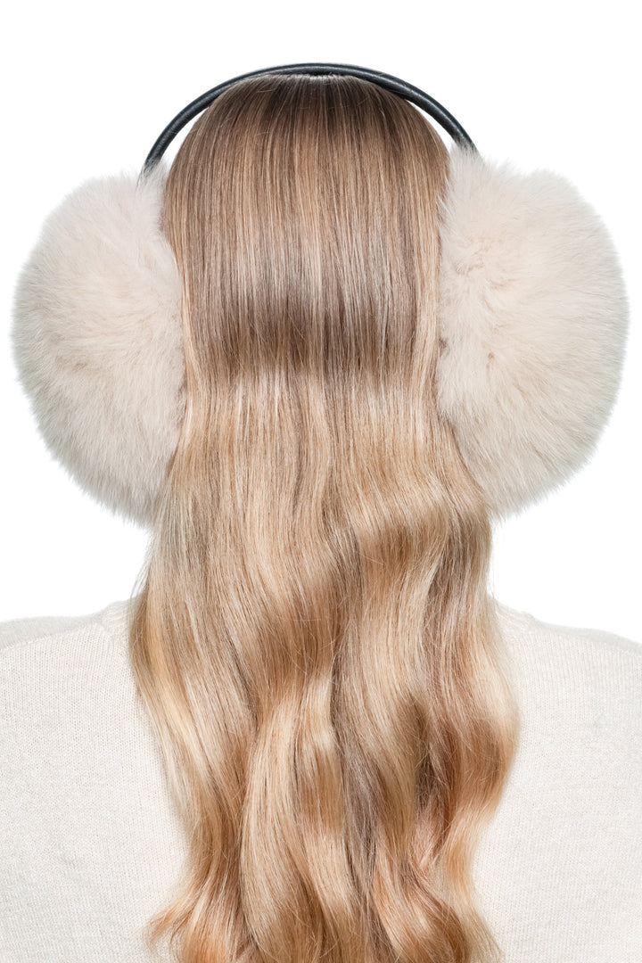 Back view of beige fox fur earmuffs showing fluffy round fur pads and sleek leather band – stylish warm ear muffs for winter.