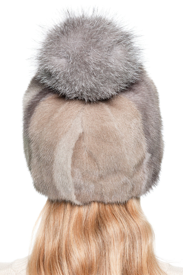 showing the back of a beige mink patchwork fur hat with fluffy silver fox pom pom. Natural color variations create a luxury textured finish.