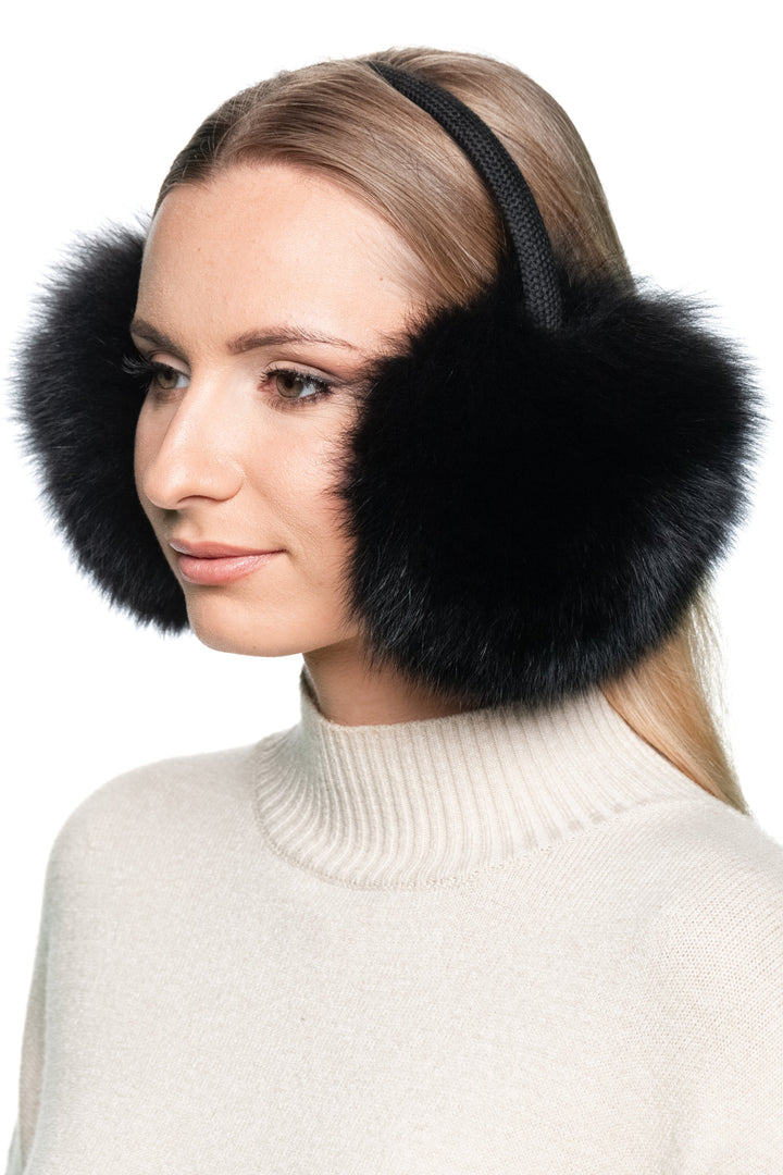 Woman wearing black fox fur earmuffs with knitted headband, luxury fluffy ear warmers for cold weather style.