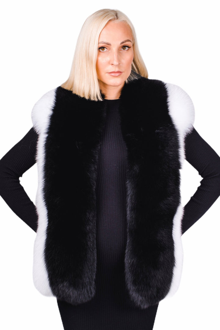 Against a plain white background, a person with blonde hair gracefully wears the "Black And White Fox Fur Stole" by FurbySD over a chic black outfit.