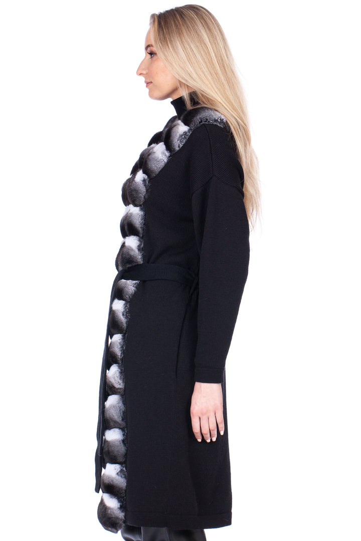 Woman wearing a black cashmere coat with chinchilla fur trim design on a white background.