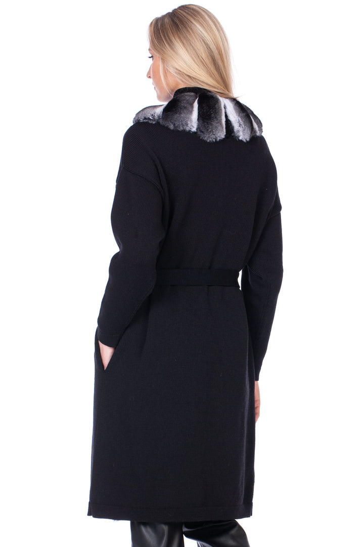 Woman wearing a black cashmere wool coat with chinchilla fur trim on a white background.