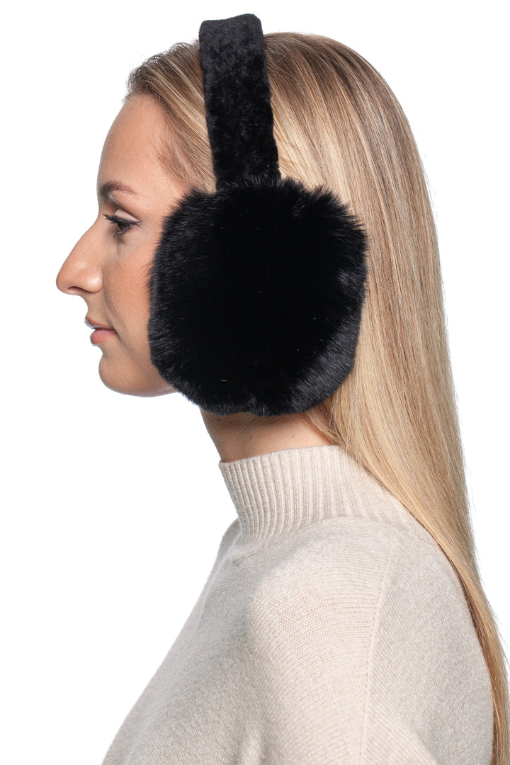 A person with long blonde hair wears FurbySD's Black Chinchilla Fur Earmuffs with an Astrakhan Band paired with a light beige sweater, depicted in profile against a white background.