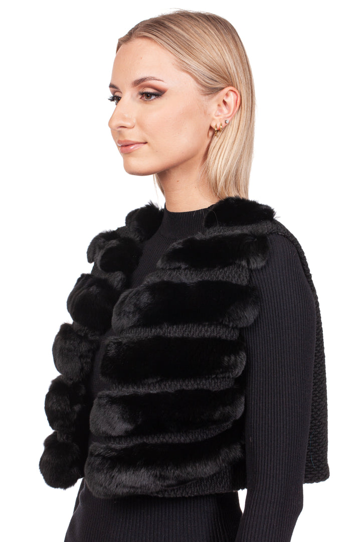 A person with blonde hair is wearing a Black Chinchilla Fur Vest With Wool by FurbySD over a premium wool sweater. They are facing left against a plain white background.