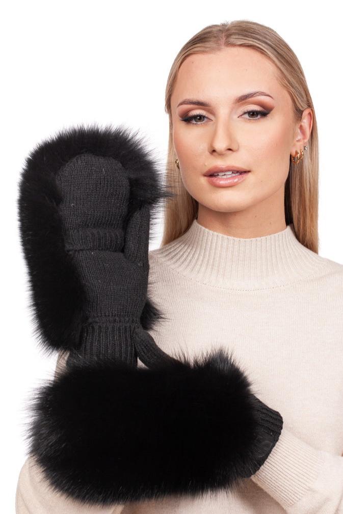 A person with long hair, dressed in a cream-colored sweater, is highlighting the luxurious Black Fox Fur Headband and Mittens by FurbySD. They smile softly while holding a single black mitten adorned with black fox fur trim near their face, perfectly accentuating the headband and mittens set.