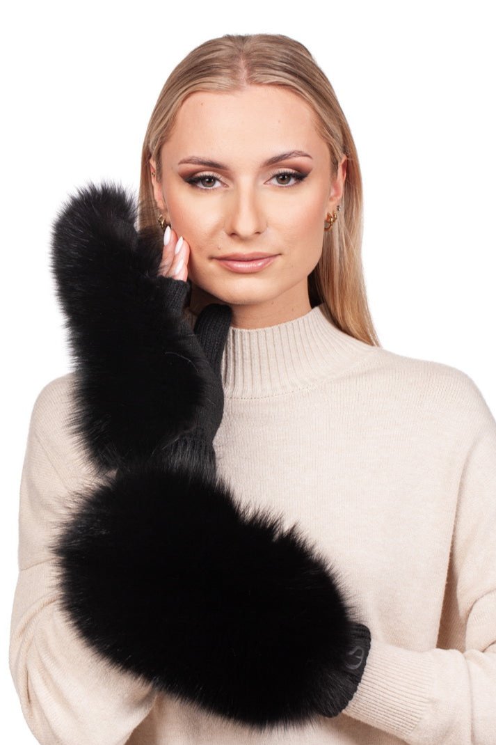 A woman in a cream sweater strikes a pose with her hand near her face, showcasing her luxurious black, fluffy gloves. She wears the elegant Black Fox Fur Headband And Mittens set by FurbySD, which beautifully highlights her straight blonde hair against the plain white background.