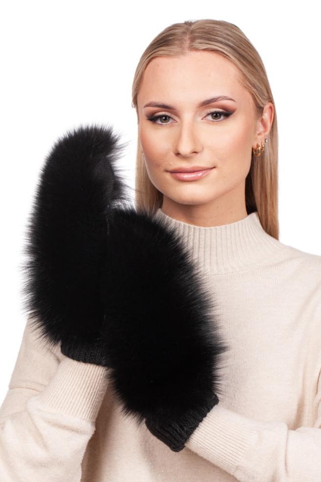 A woman sporting a beige sweater displays a pair of fluffy black mittens from the FurbySD Black Fox Fur Headband and Mittens set. Her long blonde hair frames her face as she smiles softly against the plain white backdrop.