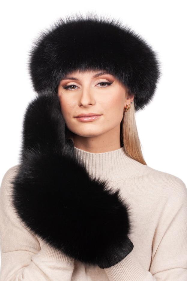 A person in a beige sweater poses with a luxury winter accessory from FurbySD—a fluffy Black Fox Fur Headband and matching mittens. The background is plain white.