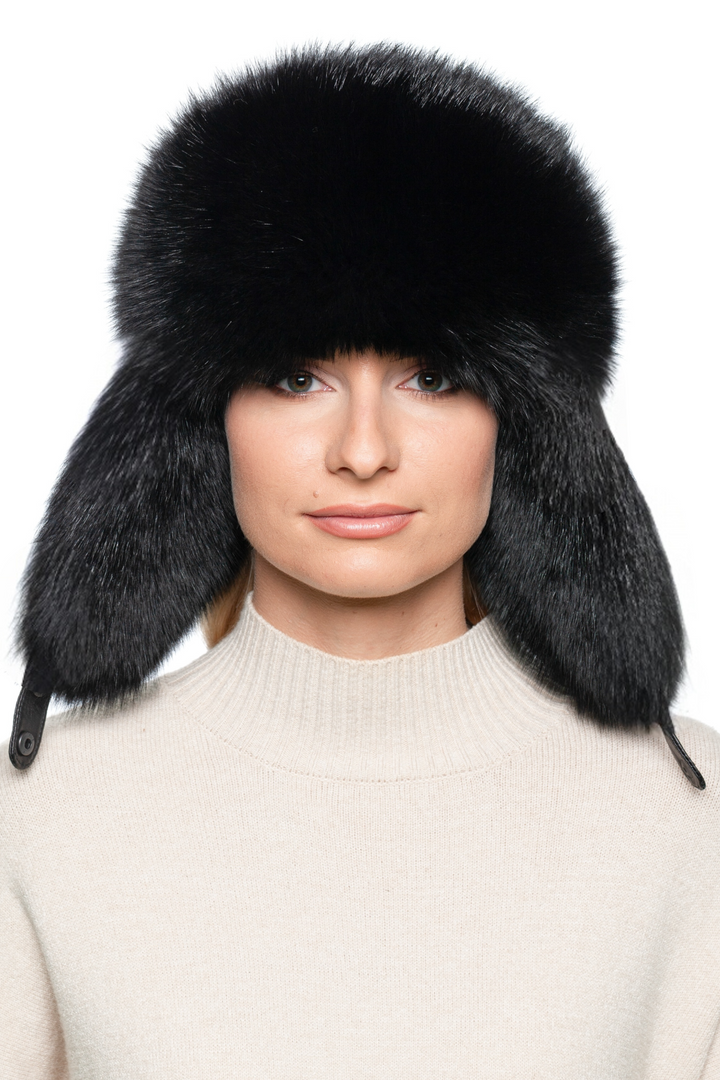 Front view of black fox fur ushanka hat with fluffy earflaps, warm real fur bomber cap for winter fashion, unisex Russian trapper ski hat.