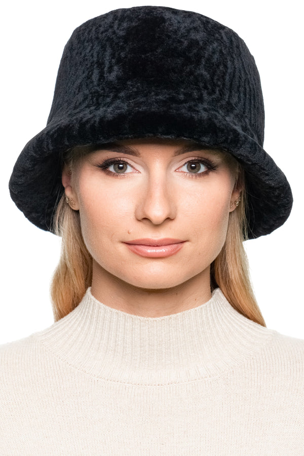 Woman wearing a black lamb fur panama bucket hat against a white background.