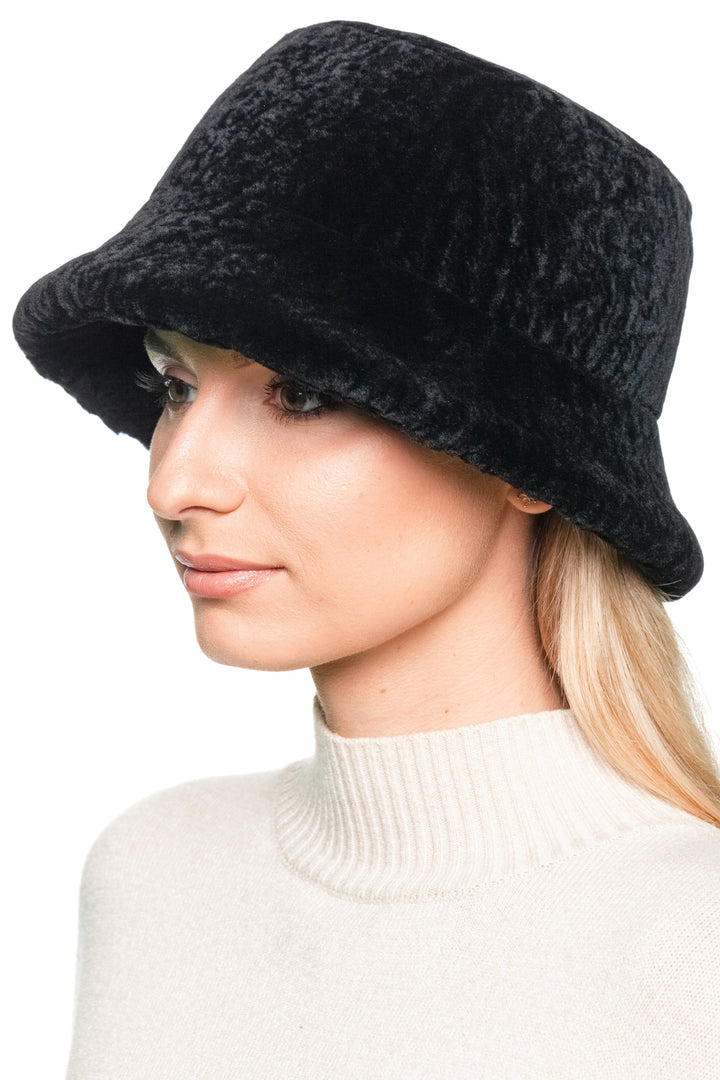 Side angle of black sheepskin bucket hat, soft lamb fur cap with flared brim, designed for men and women as retro winter headwear.