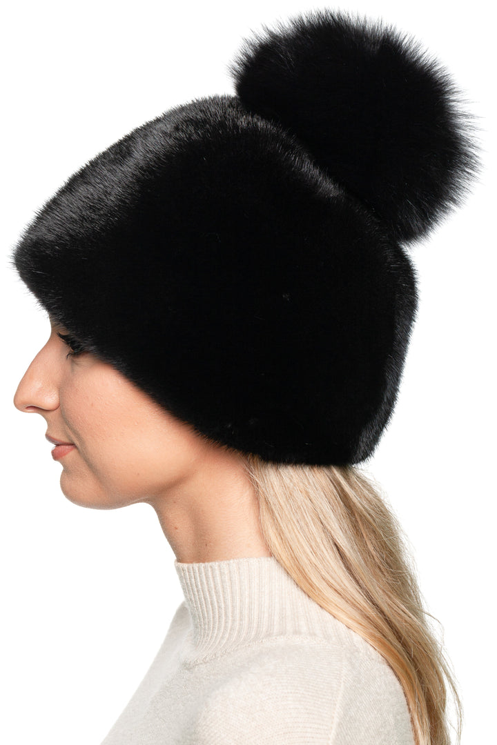 Handmade black mink fur beanie with fluffy fox fur pom pom – elegant women’s winter hat, side view.