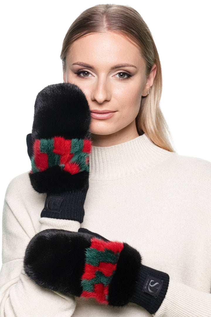 Model wearing black mink fur flip top mittens with red and green patterned wool knit front view.