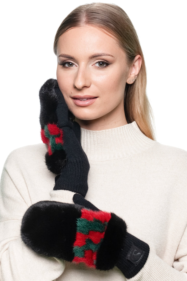 Woman wearing warm luxury mittens made of black mink fur with red and green patterned knit.