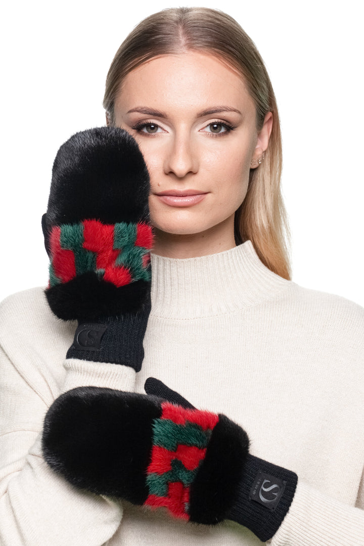 Model wearing black mink fur flip top mittens with red and green patterned wool knit front view.