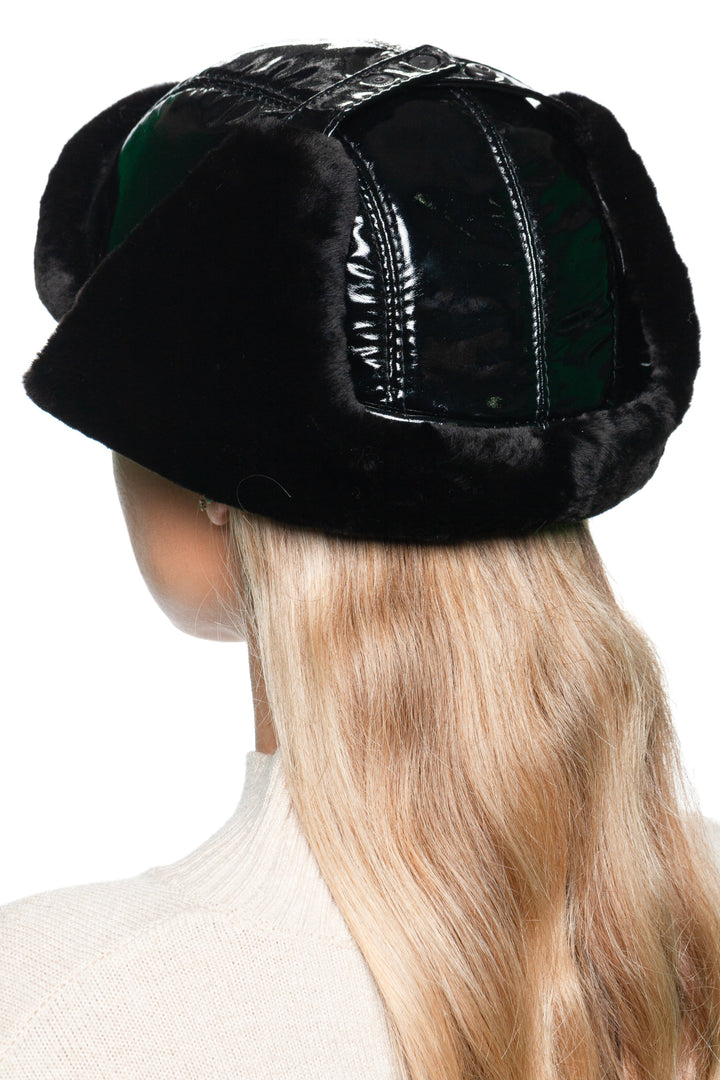 Back view of black leather and mouton fur earflap hat for women – luxury winter trapper hat with glossy black leather panels and warm shearling lining, designed for cold weather style.