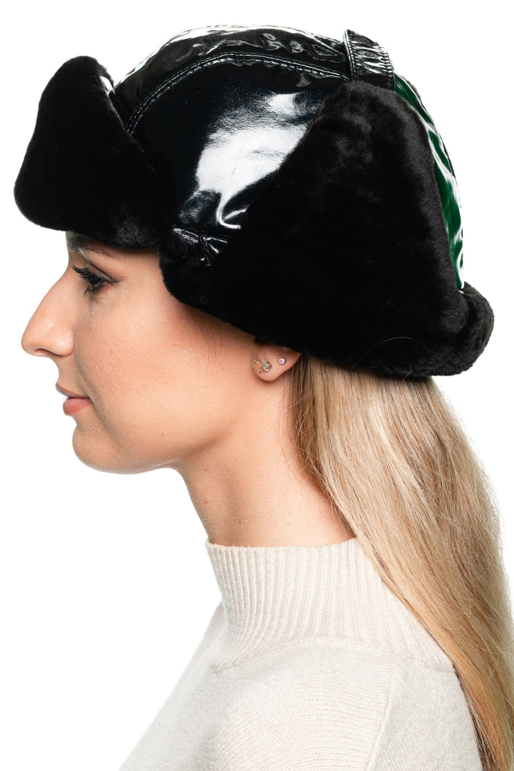 Side view of black mouton lamb fur and leather earflap hat – stylish women’s winter aviator hat with fold-down earflaps for warmth and comfort.
