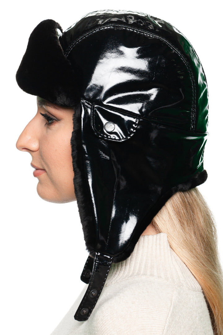 ide view of a Black Leather & Mouton Fur Earflap Hat for women, featuring glossy black leather exterior and soft shearling earflaps, luxury winter trapper hat.