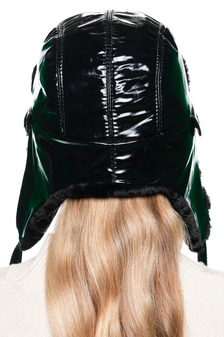 Back angle of winter Black Leather Ushanka Hat with mouton shearling lining, adjustable straps, glossy bomber cap design.
