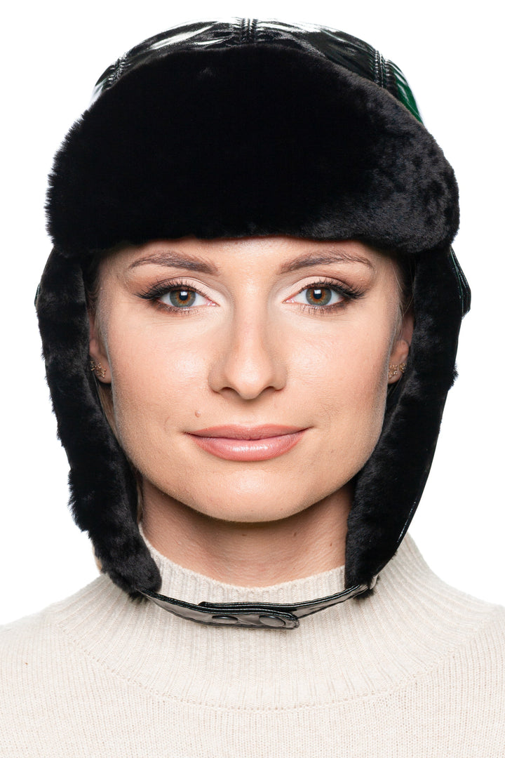 Front view of black leather and mouton fur earflap hat for women – luxury winter trapper hat with glossy black leather panels and warm shearling lining, designed for cold weather style.