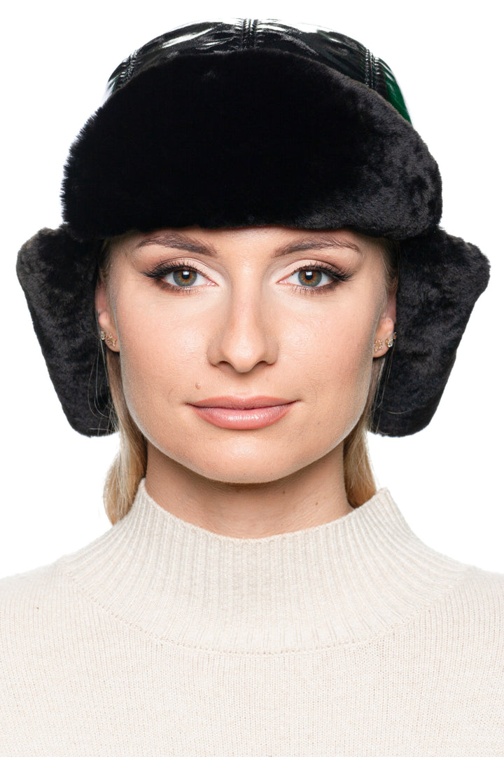 Front portrait of woman wearing black leather earflap hat with mouton fur – cozy and elegant winter trapper hat for women, handmade luxury accessory.