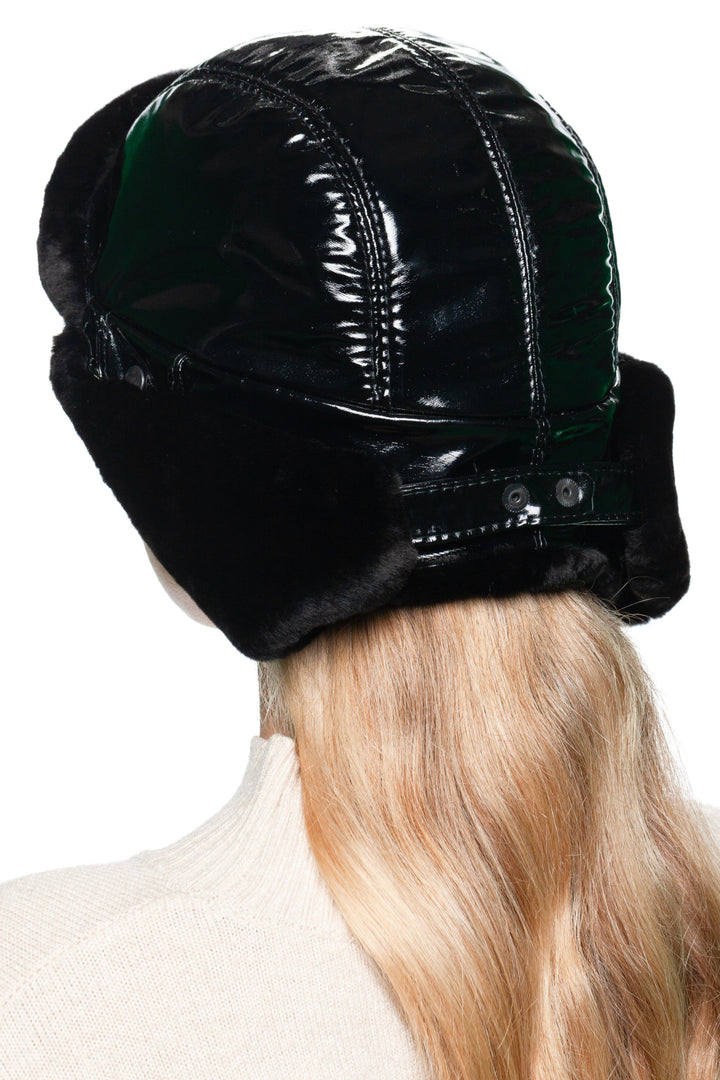 Back angle of winter Black Leather Ushanka Hat with mouton shearling lining, adjustable straps, glossy bomber cap design.