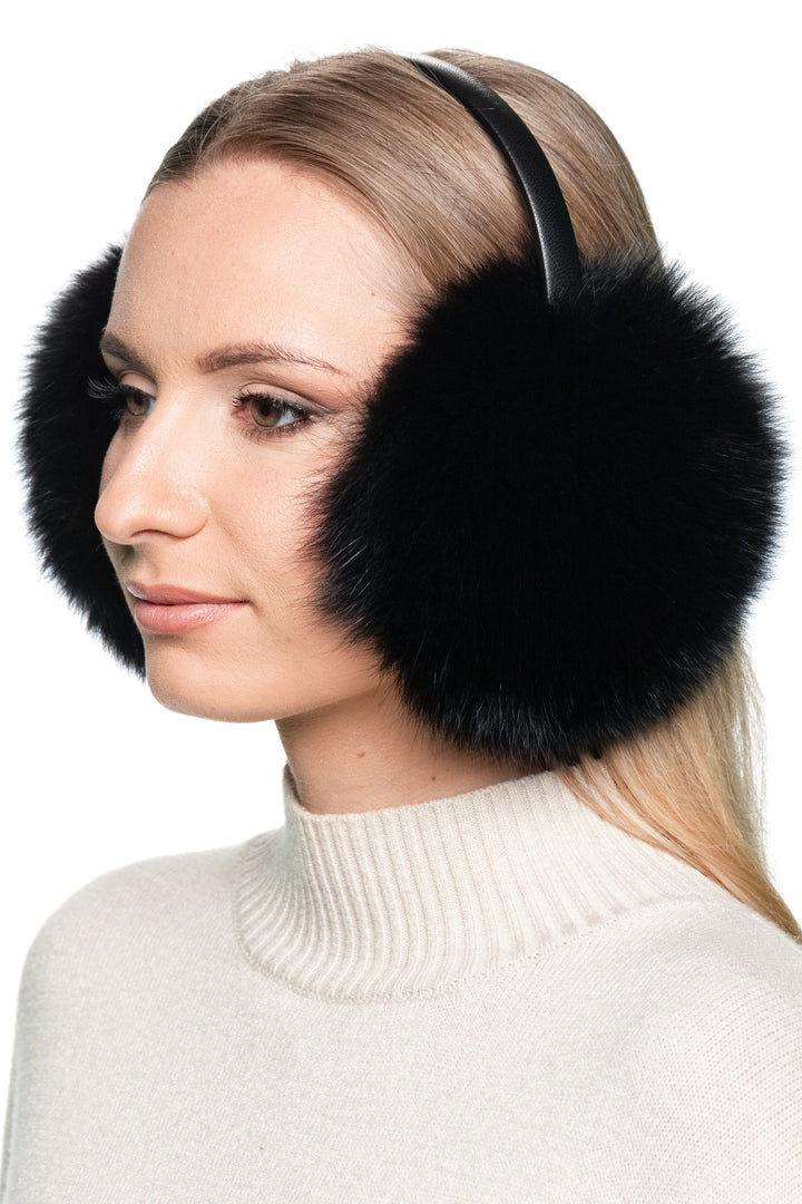 Side view of luxury black fox fur earmuffs with leather band, soft fluffy real fur ear warmers for women’s winter fashion.