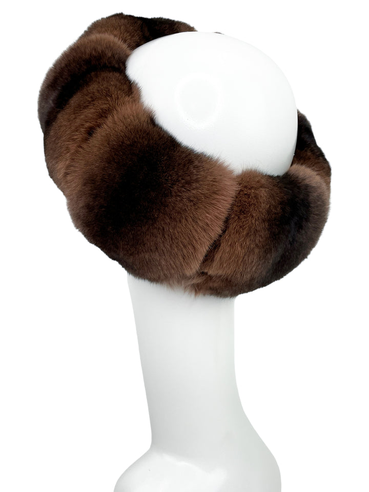 A white mannequin head showcases the FurbySD Brown Chinchilla Fur Headband, which boasts luxurious, thick, premium-quality fur that is both soft and plush. The headband is arranged in a circular fashion around the head, offering both style and warmth. The plain white background accentuates the rich texture and color of this exquisite accessory.
