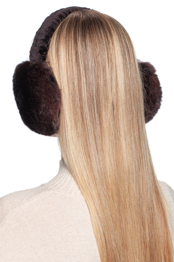 A person with long, straight blonde hair is wearing FurbySD's luxury winter accessory—a pair of Brown Chinchilla Fur Earmuffs with Astrakhan fur. They are facing away from the camera, against a plain white background.