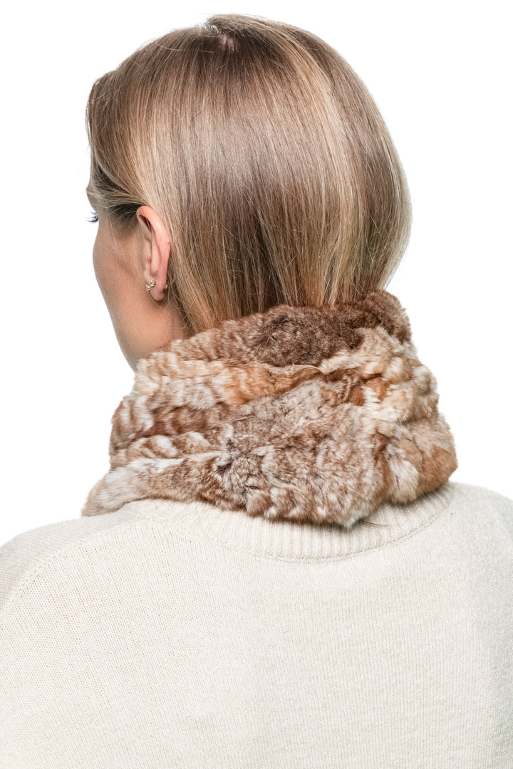 Brown chinchilla fur knitted scarf shown from the back side angle on a woman wearing a cream sweater, demonstrating full scarf coverage around the collar.