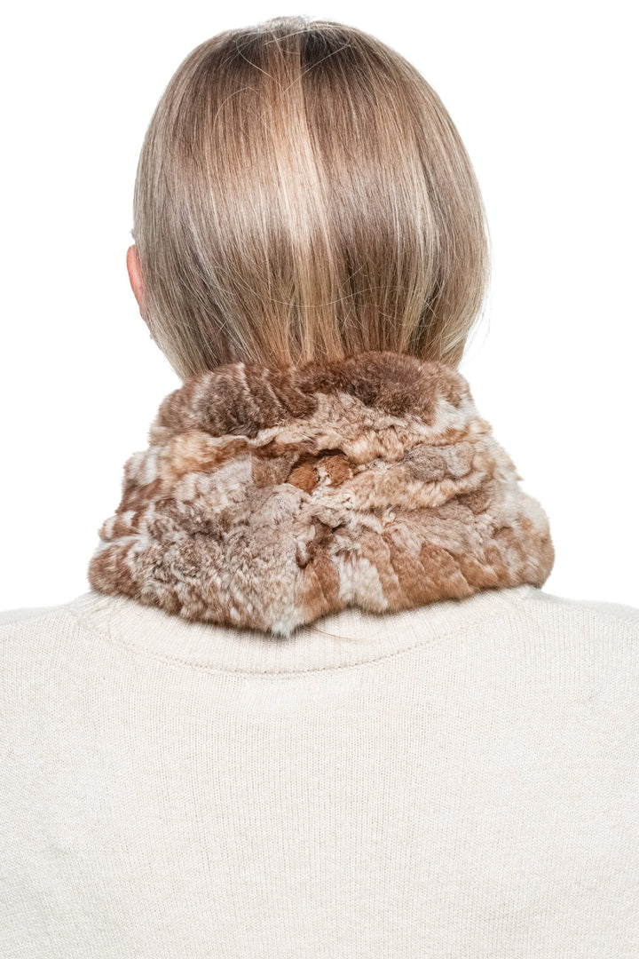 Brown chinchilla fur knitted scarf shown from the back on a woman wearing a cream sweater, demonstrating full scarf coverage around the collar.