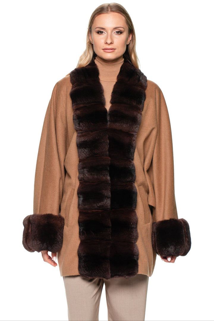 Woman wearing a brown cashmere coat with chinchilla fur trim on a white background