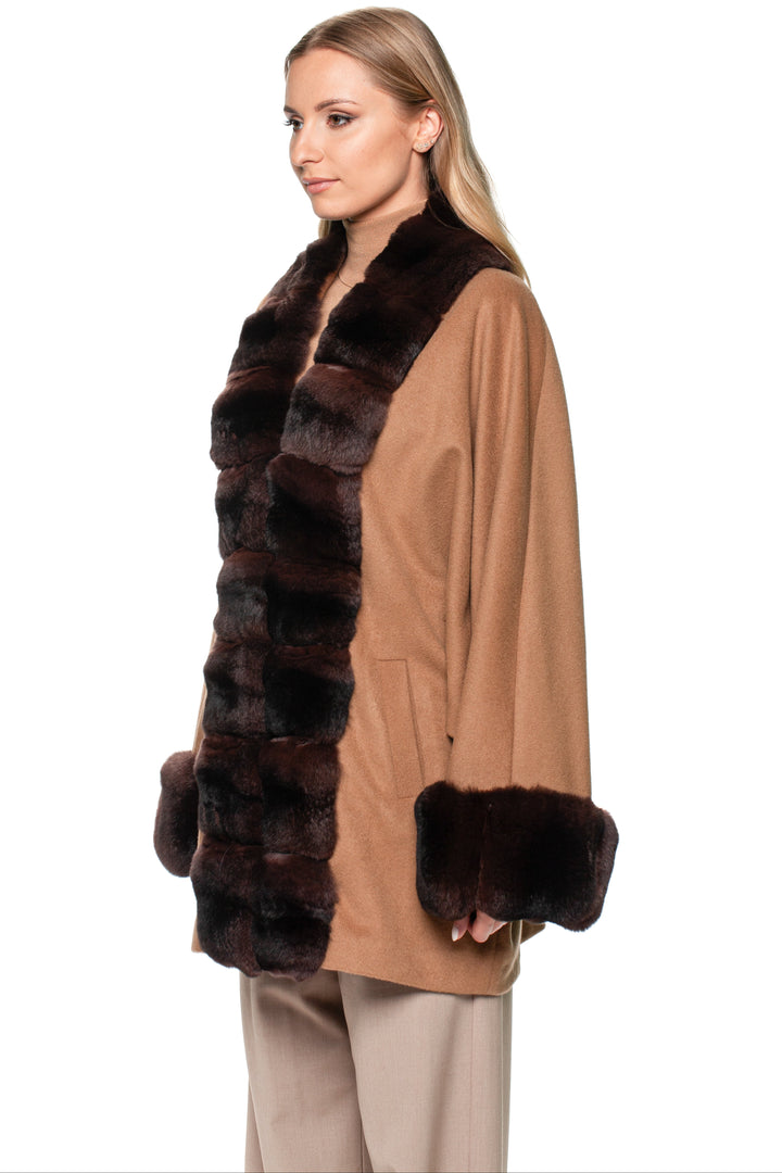 Woman wearing a brown cashmere coat with a dark brown chinchilla fur trim on a white background.