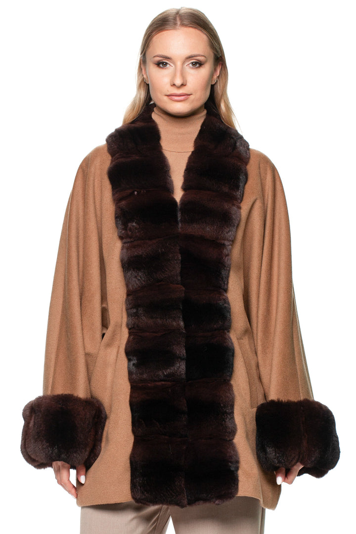 Woman wearing a brown chinchilla fur trimmed cashmere coat on a white background