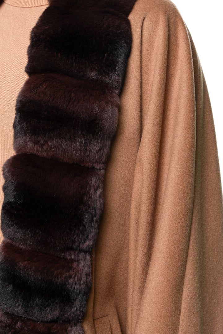 Blond woman wearing a brown cashmere coat with dark brown chinchilla fur trim on a white background.