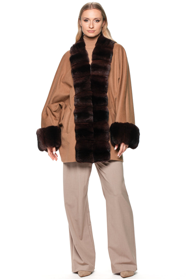 Woman wearing a brown cashmere coat with dark brown chinchilla fur trim on a white background