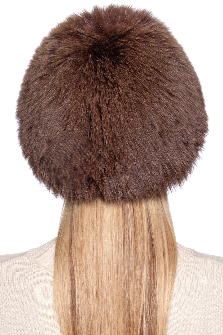 Back view of a luxurious brown fox fur knit beanie hat on a woman with long blonde hair.