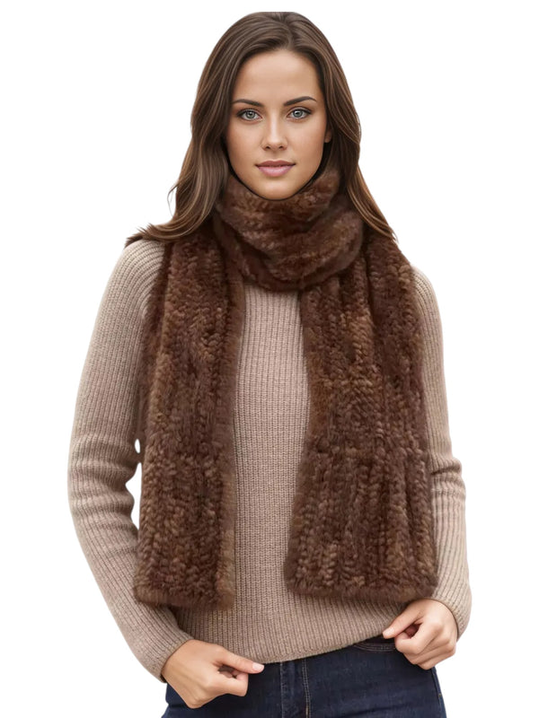 A person wearing a FurbySD Brown Knitted Mink Fur Scarf and a beige sweater is standing against a white background. Their long brown hair cascades down as they face forward, with hands resting by their sides.