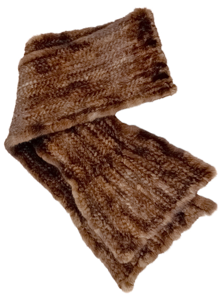 A Brown Knitted Mink Fur Scarf by FurbySD is laid out flat, highlighting its soft, fluffy texture and rectangular shape. It features various shades of brown that create a natural, warm appearance similar to ethically sourced faux fur.