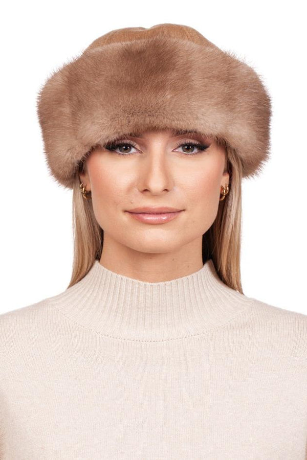 A person wearing a luxurious Brown Mink Fur and Cashmere Hat by FurbySD, paired with a light sweater against a white background. The hat's soft, fluffy texture enhances the cozy appearance of the outfit. The person's neutral expression embodies the essence of luxury winter accessory fashion.