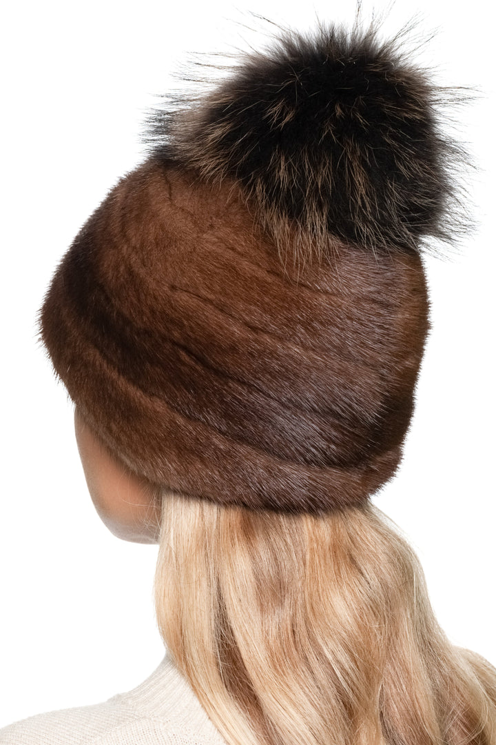 Brown striped mink fur hat with a matching brown large fox fur pom-pom on a white background