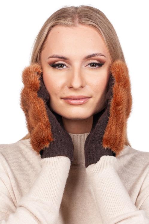 A smiling person with long hair gently touches their face while wearing a beige sweater and the luxurious Rust Brown Mink Fur Mittens from FurbySD, set against a plain white background.