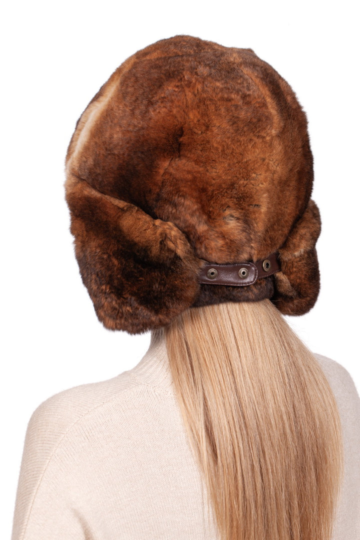 Woman with long blonde hair wearing a luxurious brown  rabbit fur trapper hat, back view, white background.