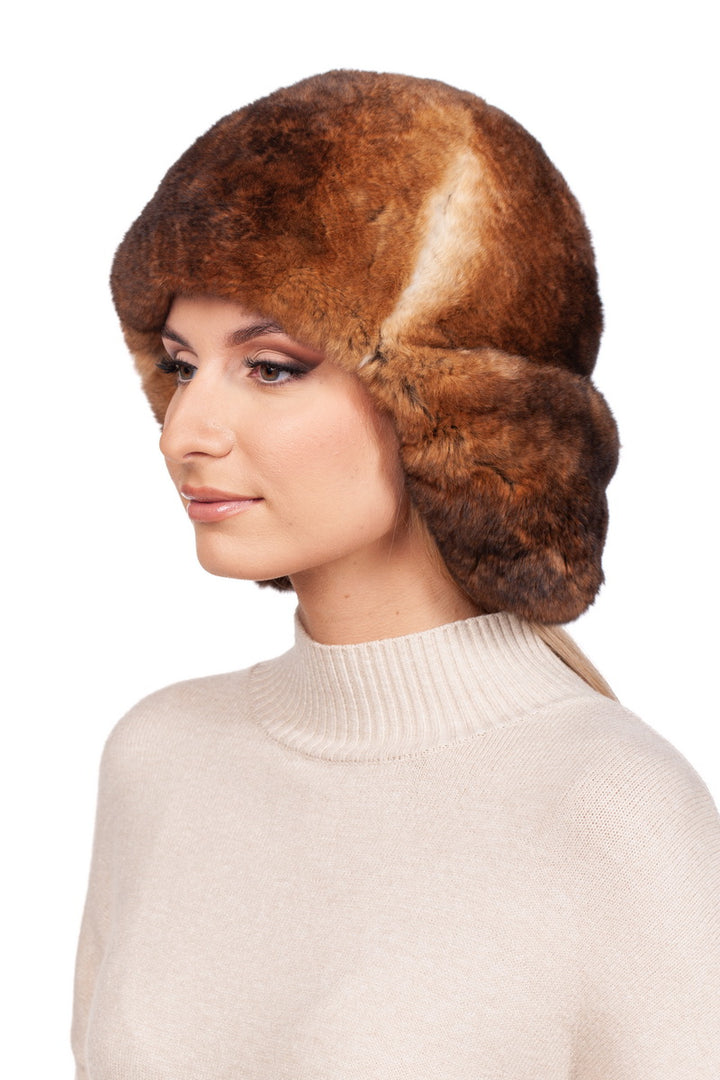 Profile view of a woman wearing a brown rex rabbit fur trapper hat and a beige turtleneck sweater, highlighting winter fashion accessories.