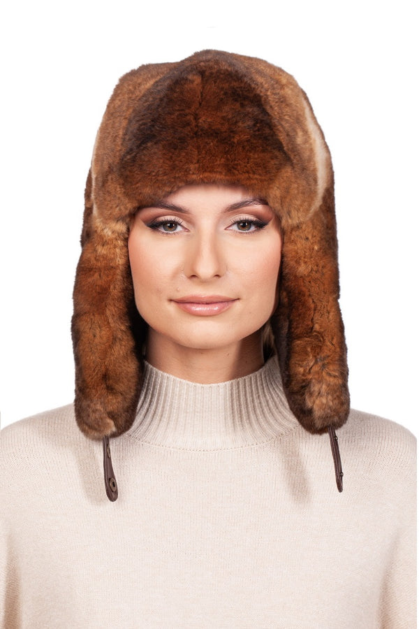 Person in a beige sweater wearing a brown rex rabbit fur ushanka cap.