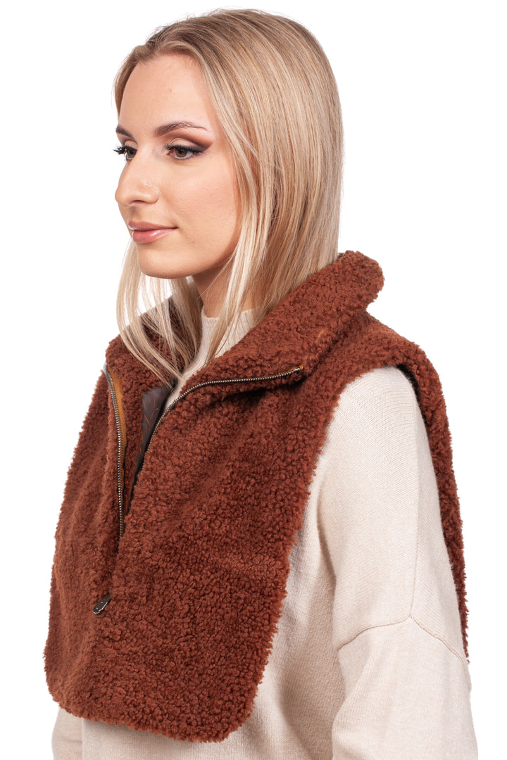 A woman with long blonde hair is wearing a beige sweater and the Brown Shearling Fur Turtleneck Collar from FurbySD. The vest features a zippered front and extends to cover her shoulders, as she gazes off to the side against a white background.