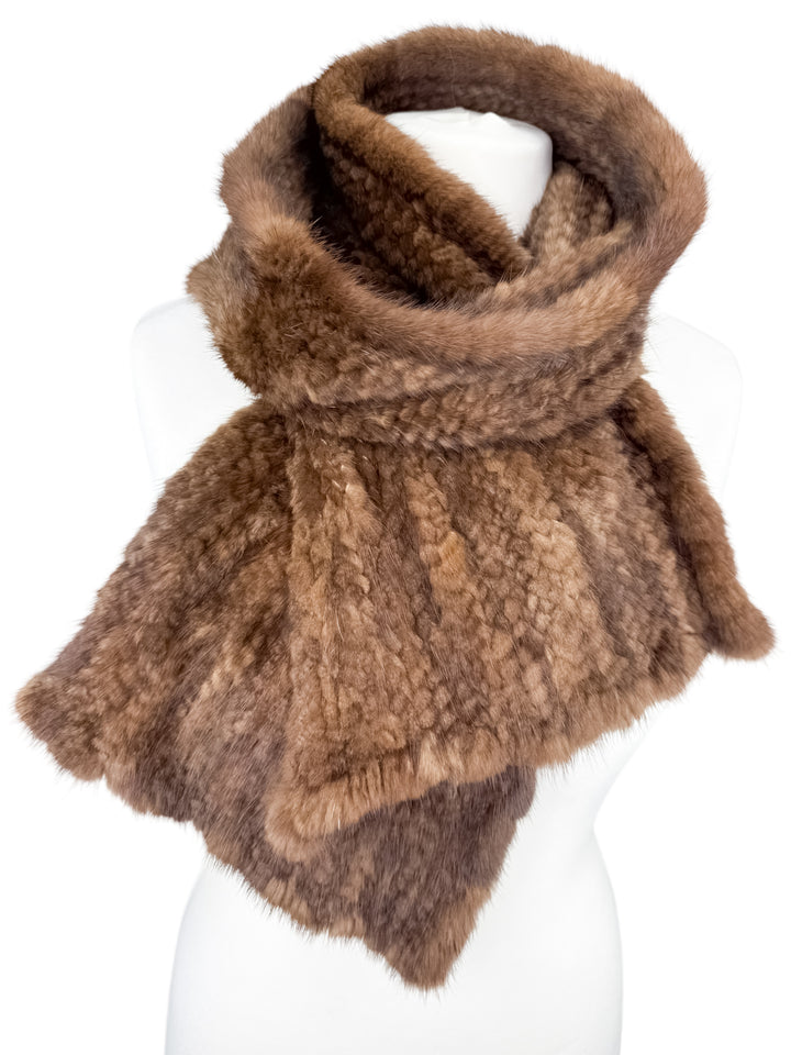 A glamorous Brown Knitted Mink Fur Scarf from FurbySD is gracefully displayed on a white mannequin, highlighting its plush texture and deep natural brown color.